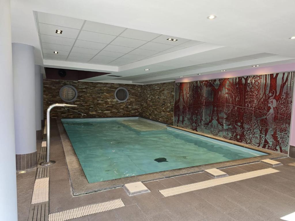 - une grande piscine dans une pièce dotée d'un mur en briques dans l'établissement Super appart Risoul Alpes du Sud, à Risoul 19 autres photos