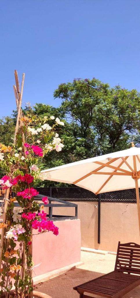- un parasol blanc, une table et des fleurs dans l'établissement Riad Sarasvati, à Marrakech 6 autres photos