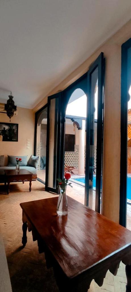 un salon avec une table en bois et un canapé dans l'établissement Riad Sarasvati, à Marrakech