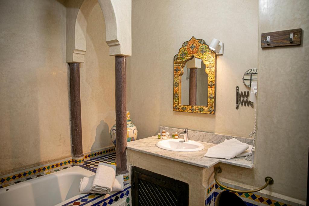 une salle de bain avec un lavabo, une baignoire et un miroir dans l'établissement Riad Bab Chems, à Marrakech