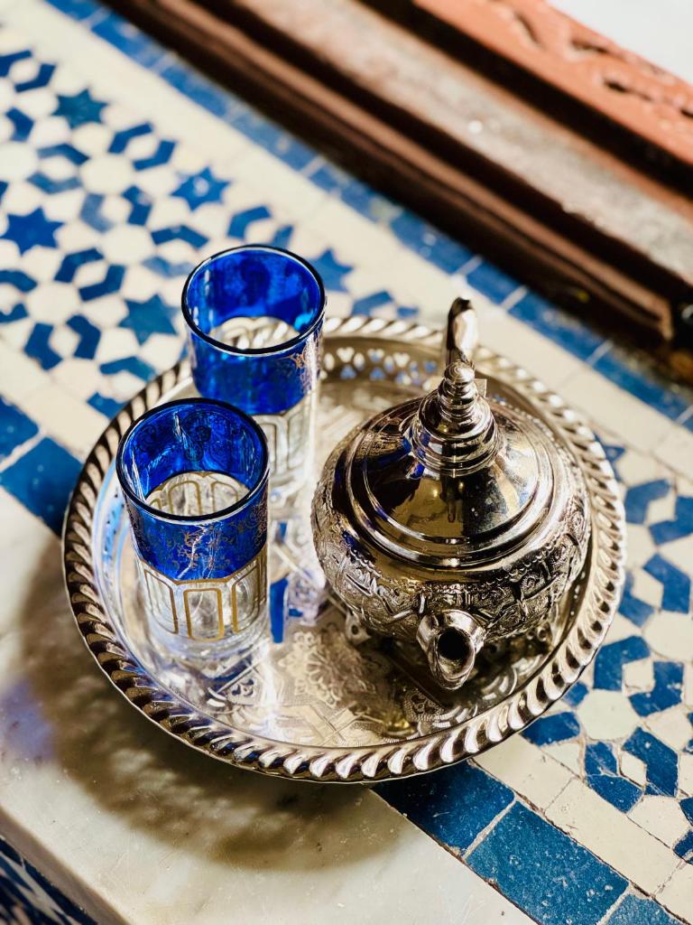 un plateau en argent avec trois verres bleus sur une table dans l'établissement Riad Zawiyat Fes, à Fès