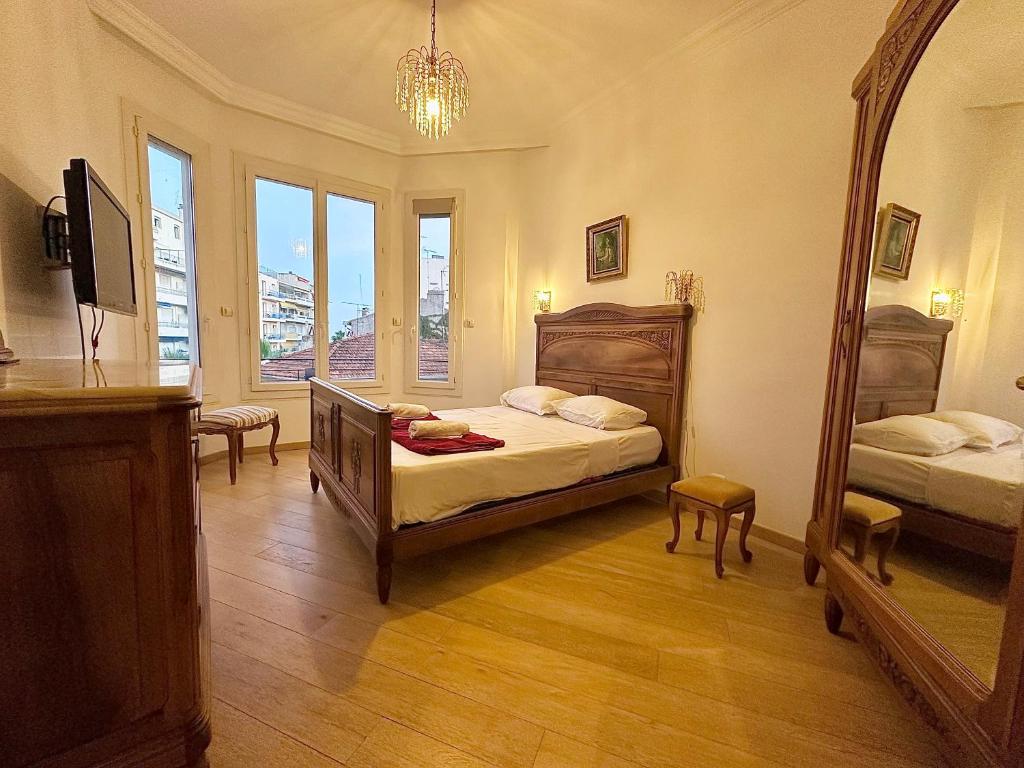 une chambre avec deux lits et un grand miroir dans l'établissement 3 pièces 100m2 balcon centre juan 2 pas des plages, à Antibes