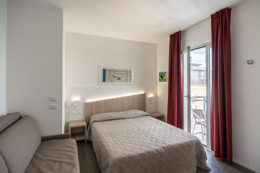 une chambre avec un lit, un canapé et une fenêtre dans l'établissement Hotel Marzia Holiday Queen, à Caorle 43 autres photos