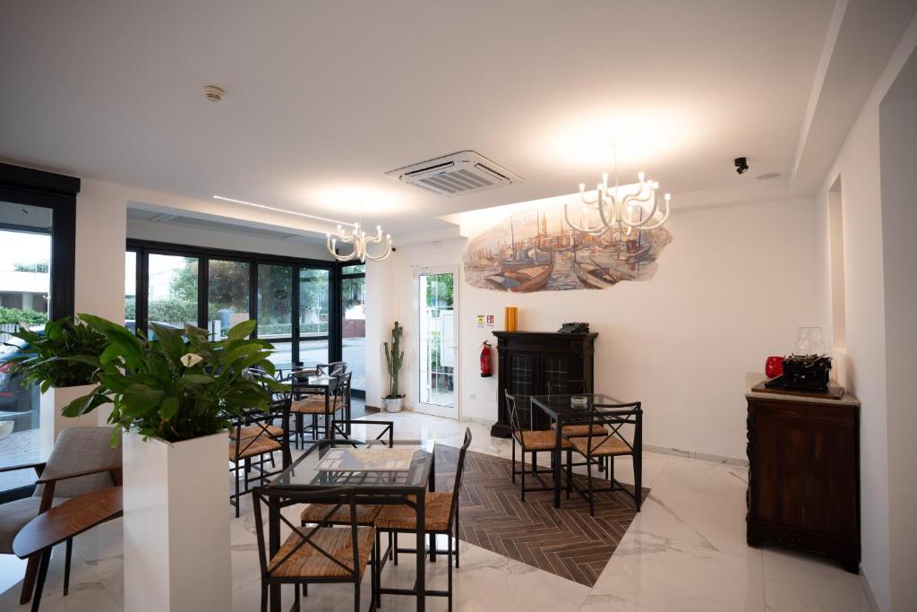 une salle à manger avec une table, des chaises et un lustre dans l'établissement Hotel Marzia Holiday Queen, à Caorle