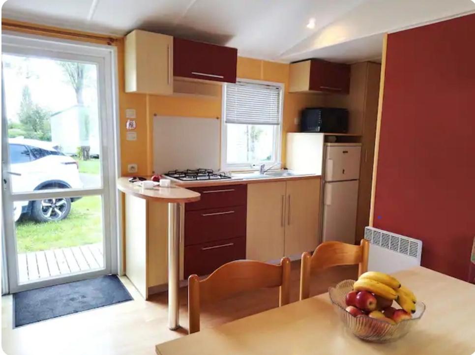 une cuisine avec une table avec un bol de fruits dessus dans l'établissement Mobilhome 5 place proche mer, à Angles