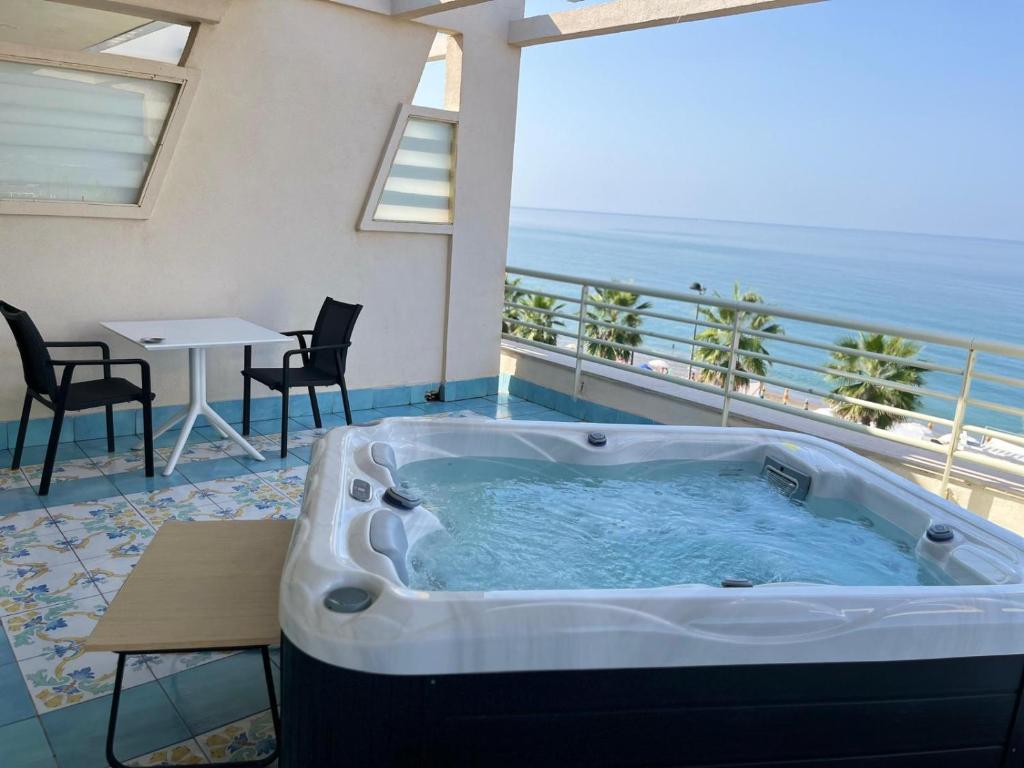 un bain à remous sur un balcon avec une table et des chaises dans l'établissement Hotel Ancora, à Pontecagnano