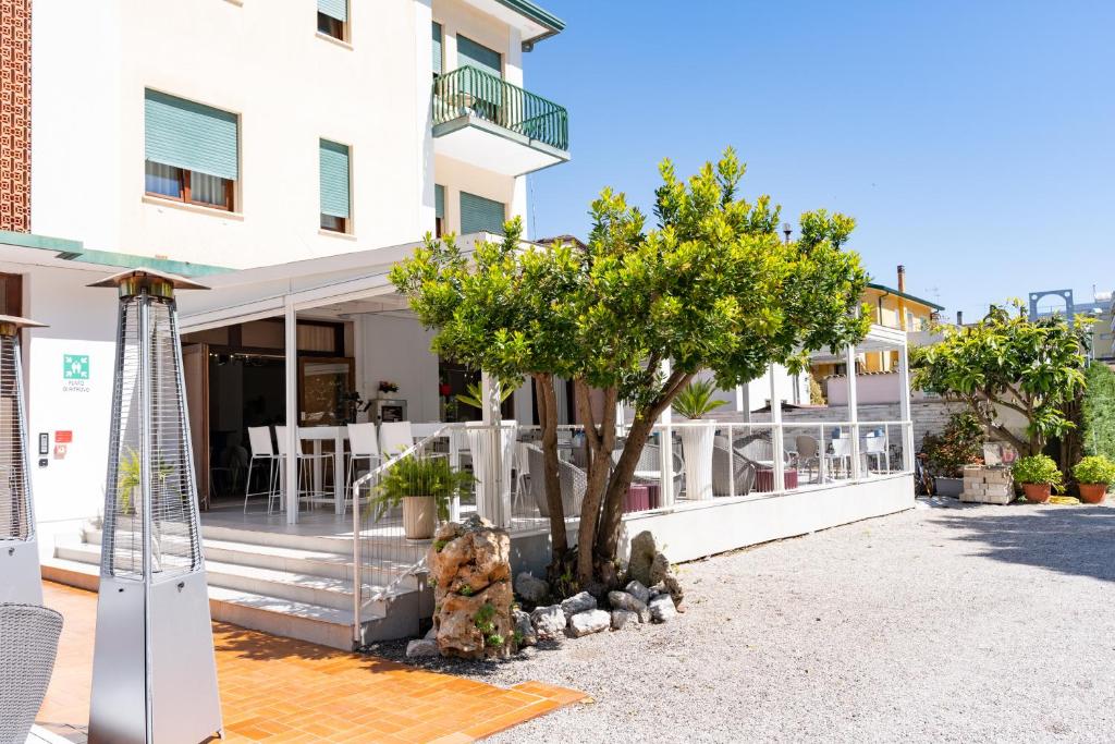une maison avec un arbre devant un bâtiment dans l'établissement Hotel Regina, à Caorle