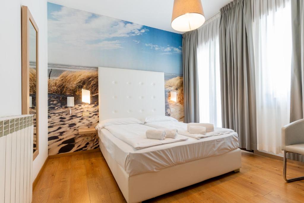 une chambre avec un lit et un tableau au mur dans l'établissement Hotel Regina, à Caorle