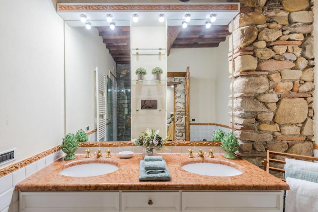 une salle de bain avec deux lavabos et un grand miroir dans l'établissement Citrus Charm Farmhouse, a Country Villa with Pool, à Capannori