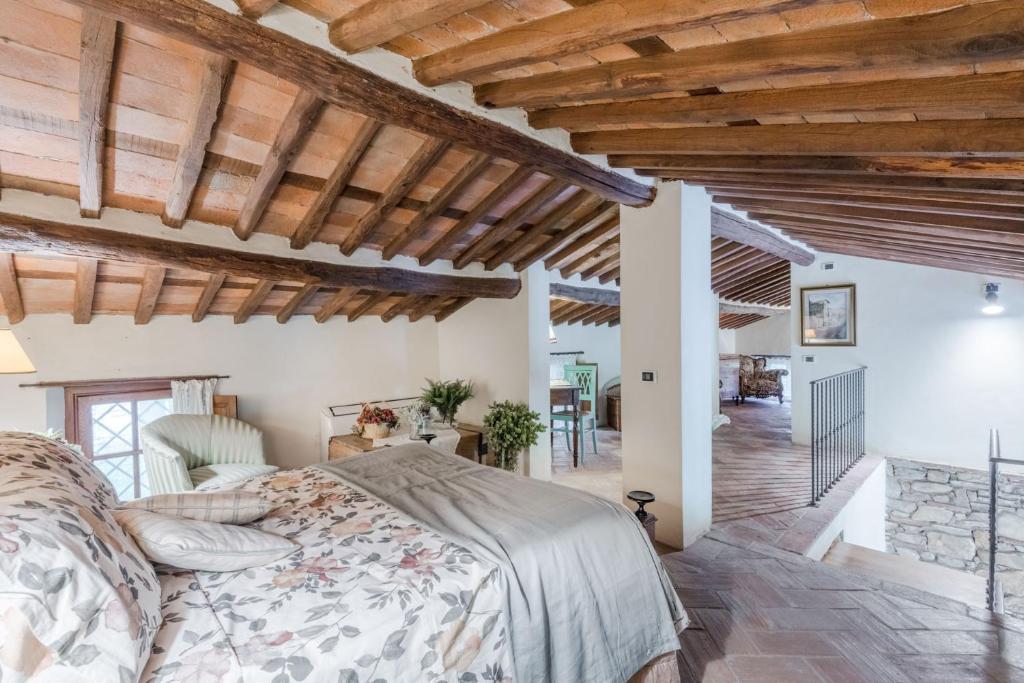 une chambre avec un lit dans une pièce avec des plafonds en bois dans l'établissement Citrus Charm Farmhouse, a Country Villa with Pool, à Capannori
