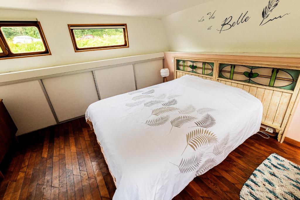 - une chambre avec un lit blanc et 2 fenêtres dans l'établissement Nuit insolite à bord d'une péniche, 6 personnes, à Bergues