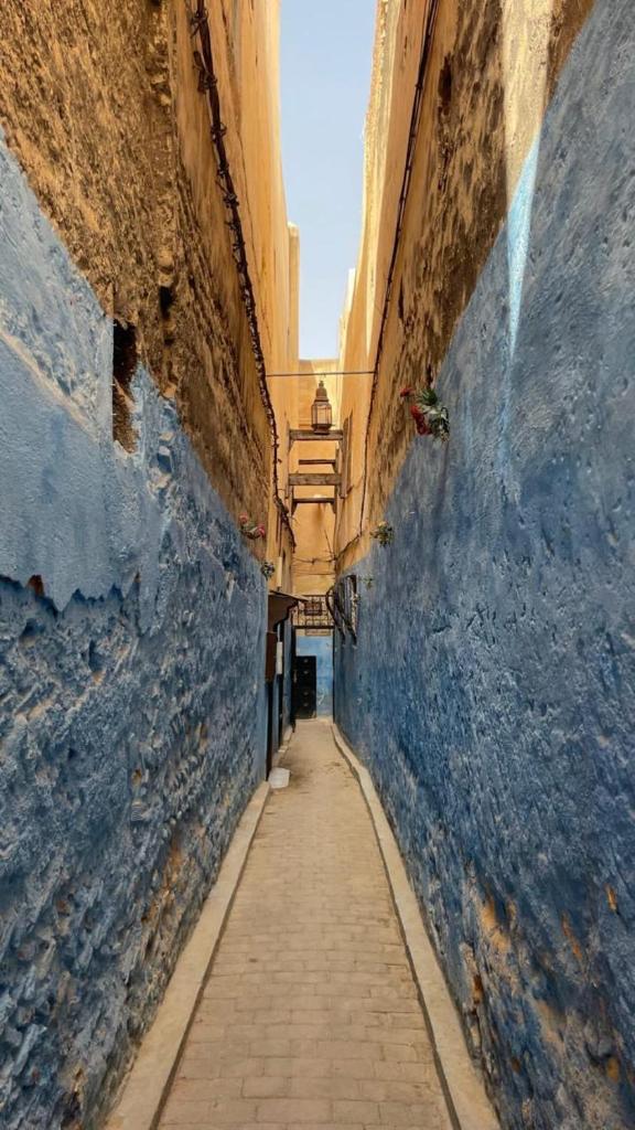 Une allée avec un mur bleu et une ruelle étroite dans l'établissement Dar Fès Huda, à Fès