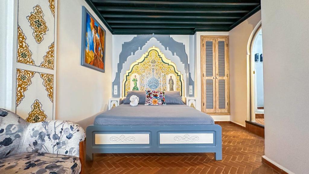 une chambre avec un lit avec un tableau sur le mur dans l'établissement PALACIO AL ANDALUS, à Chefchaouen