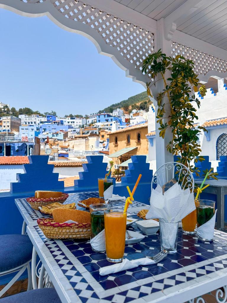 une table avec de la nourriture et des boissons sur un balcon dans l'établissement PALACIO AL ANDALUS, à Chefchaouen