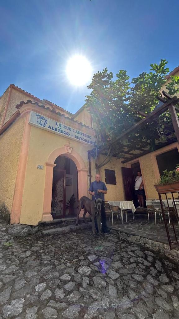 un homme avec un cheval devant un bâtiment dans l'établissement Le Due Lanterne, à Aieta