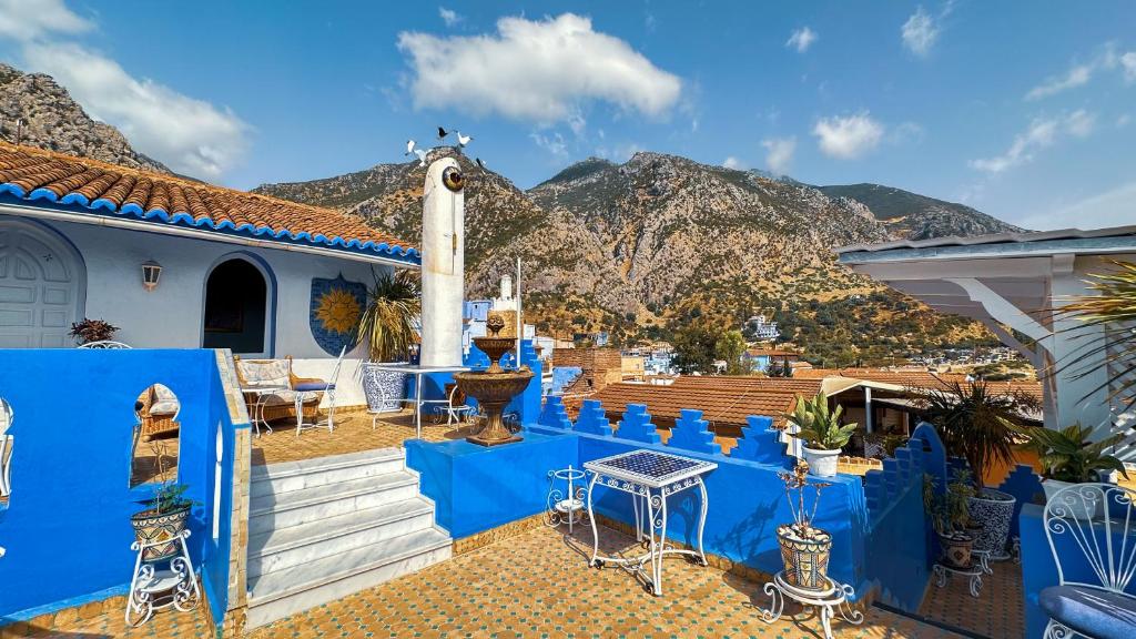 une maison avec des murs bleus et des montagnes en arrière-plan dans l'établissement PALACIO AL ANDALUS, à Chefchaouen