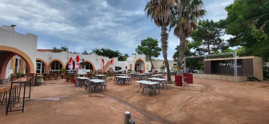 - un groupe de tables et de chaises dans une cour dans l'établissement Mobil home - Camping La Palmeraie, à Torreilles