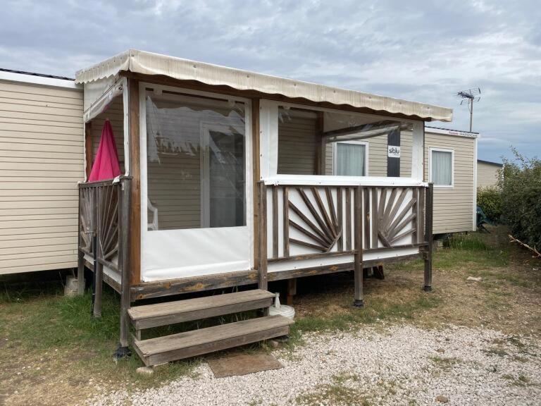 une petite maison avec une terrasse couverte sur le côté. dans l'établissement Le lac des rêves à Lattes, à Lattes