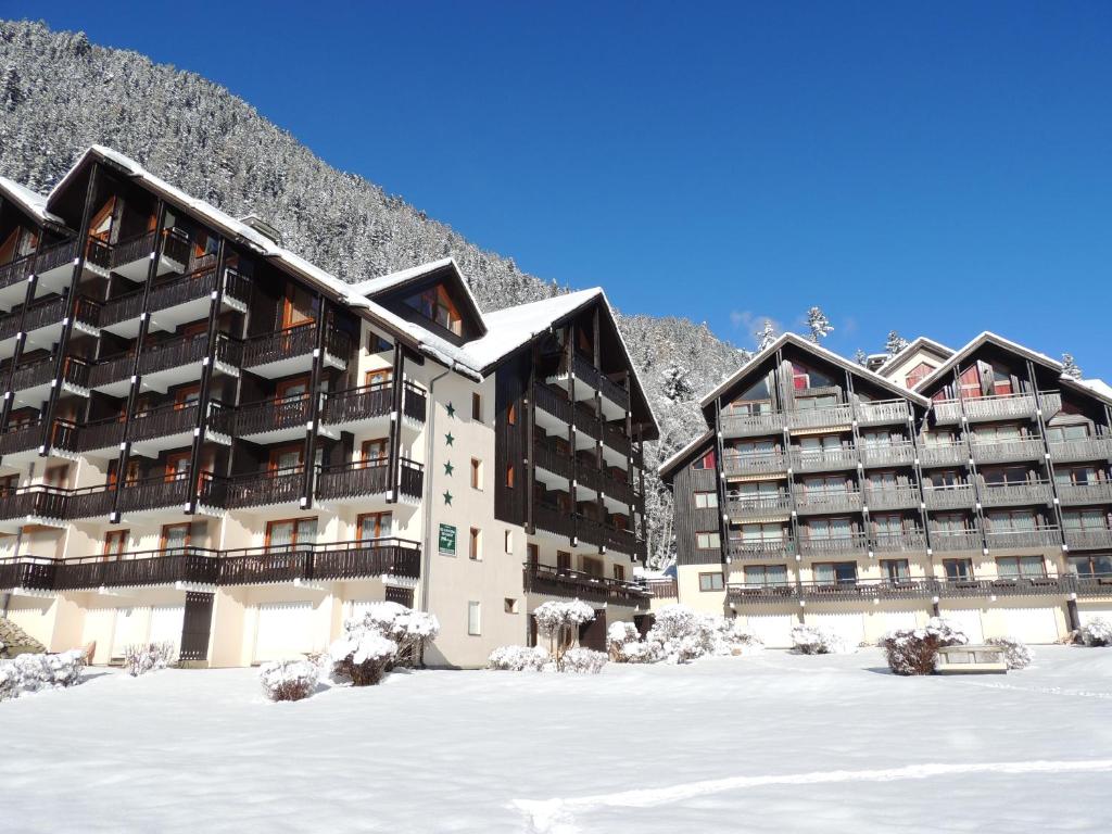 un bâtiment dans la neige devant une montagne dans l'établissement Les Balcons du Savoy, à Chamonix-Mont-Blanc