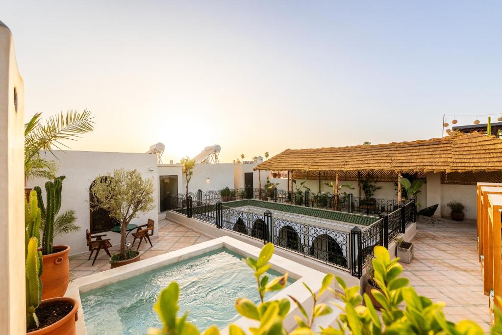 une maison avec une piscine sur une terrasse dans l'établissement Alrashid Marrakech - Hotel & SPA, à Marrakech