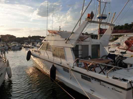 un bateau blanc est amarré dans l'eau dans l'établissement Insolite, à Capbreton