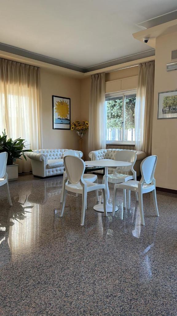 un salon avec une table, des chaises et un canapé dans l'établissement Hotel Costa Verde, à Tortoreto Lido