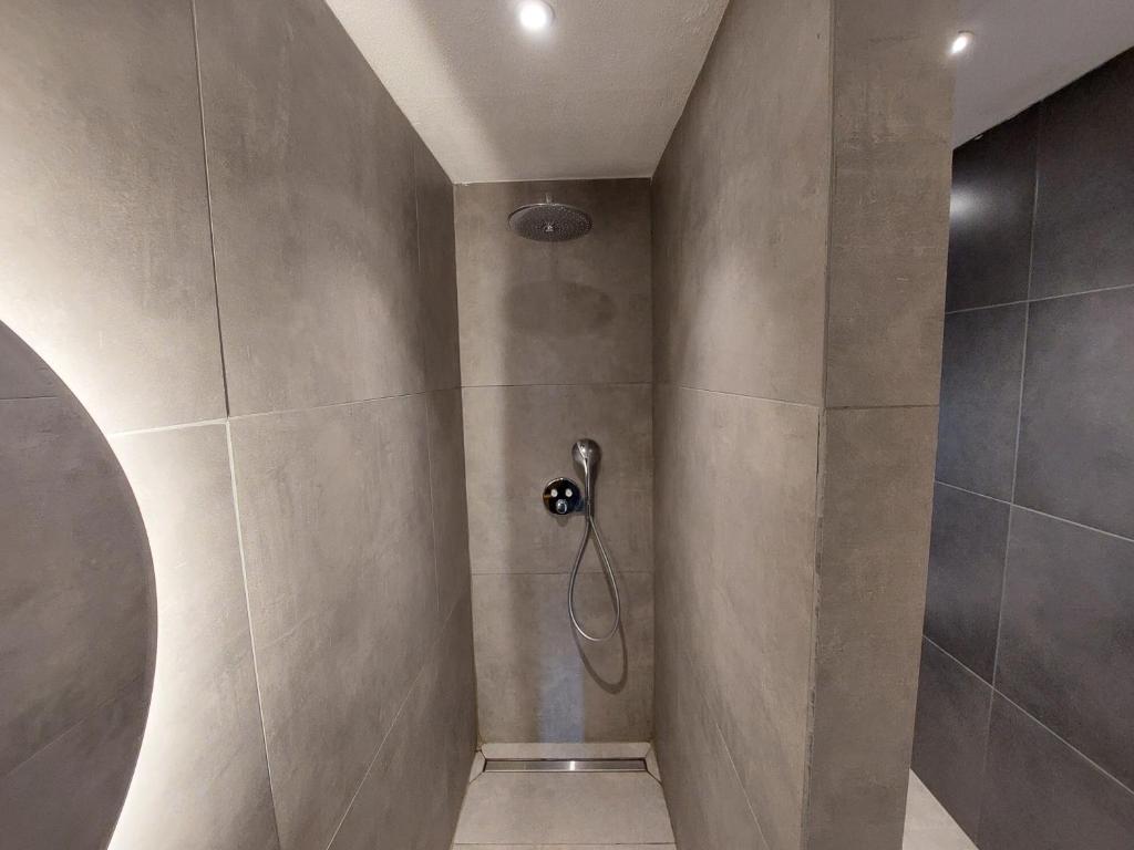 La salle de bains est pourvue d'une cabine de douche avec un pommeau de douche. dans l'établissement Gite Charassat, à Saint-Marcel-en-Marcillat