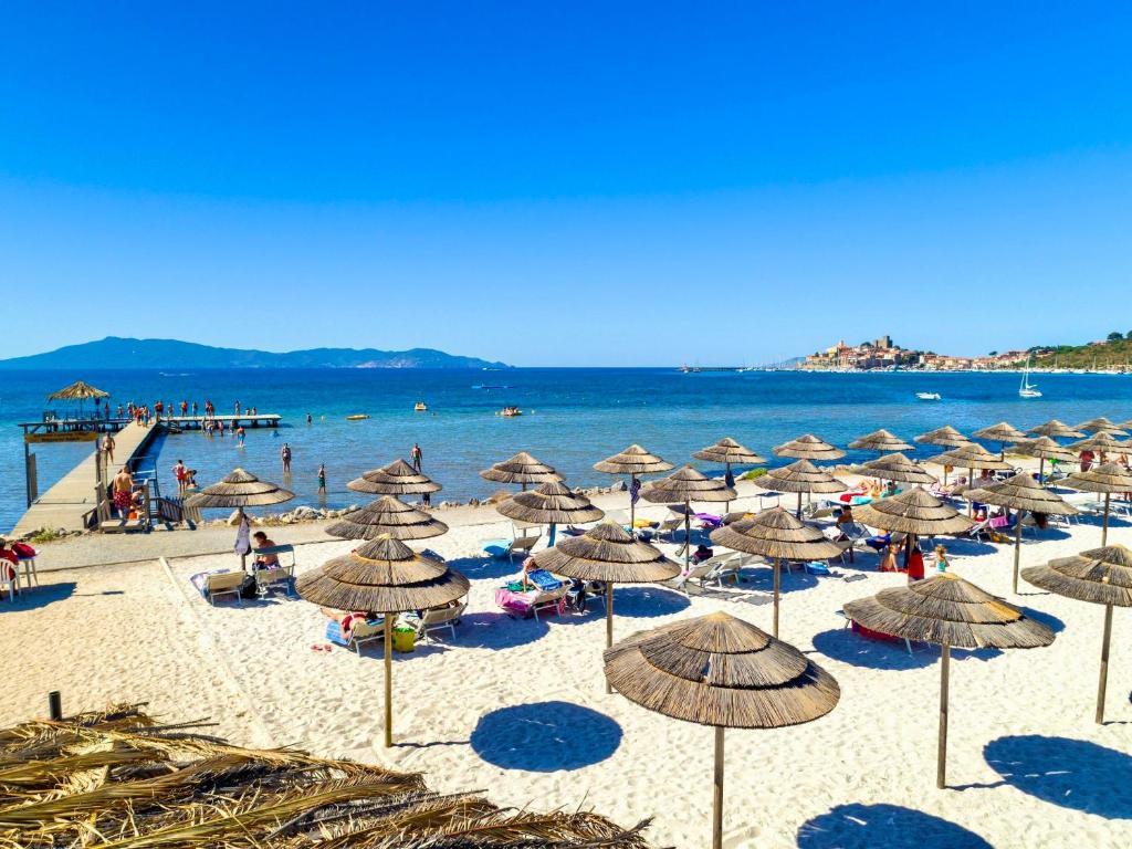 une plage avec beaucoup de parasols et de monde dessus dans l'établissement ISA - Residence with pool and private beach in Talamone just 500 mt from the beach, à Talamone