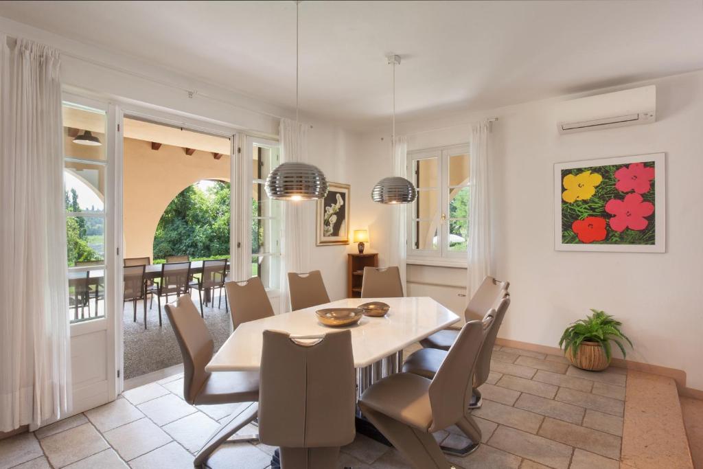 une salle à manger avec une table et des chaises dans l'établissement Villa Gasco With Pool, à Lazise
