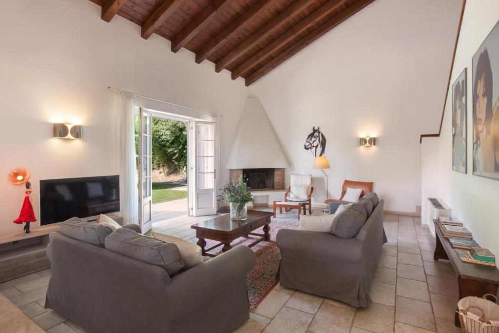 un salon avec deux canapés et une télévision dans l'établissement Villa Gasco With Pool, à Lazise