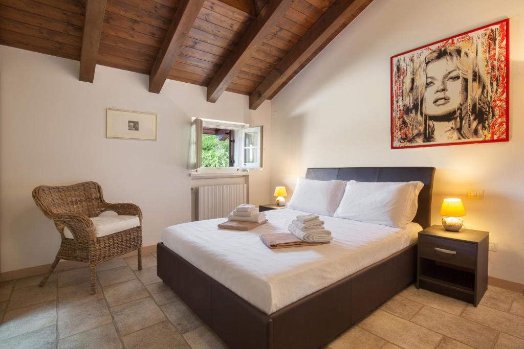 une chambre avec un lit et une chaise dedans dans l'établissement Villa Gasco With Pool, à Lazise