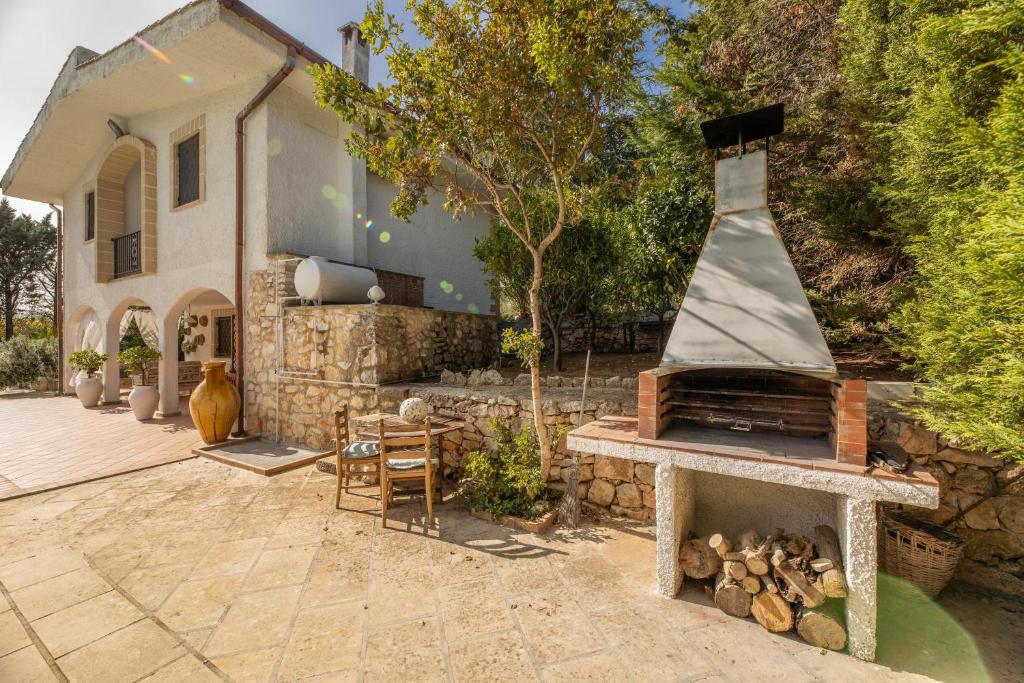 une cour arrière avec un four à pizza devant une maison dans l'établissement Villa Corallo, à Villa Castelli