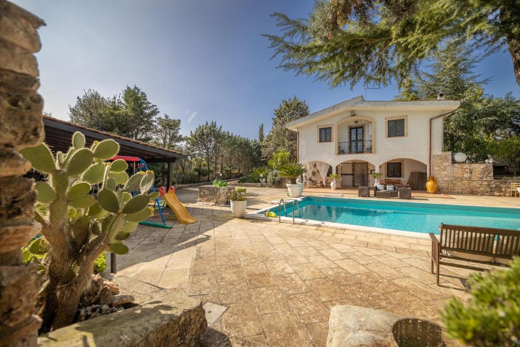 une villa avec piscine devant une maison dans l'établissement Villa Corallo, à Villa Castelli