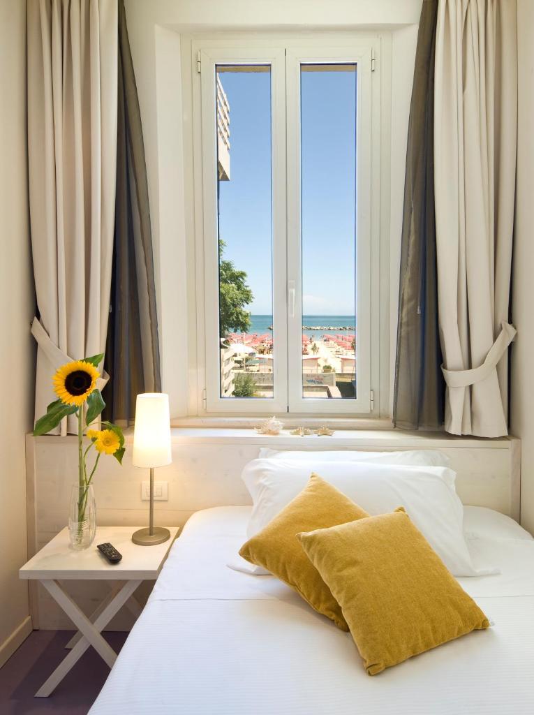 une chambre avec un lit avec une grande fenêtre dans l'établissement Hotel LaMorosa, à Rimini
