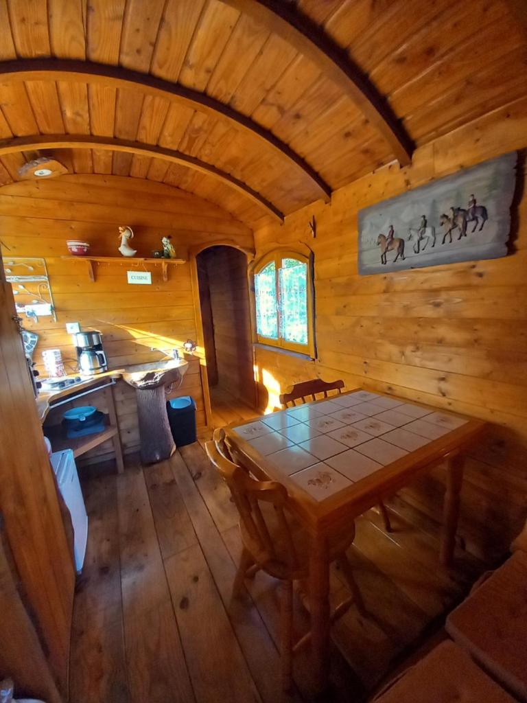- une vue de tête sur une cabane en bois avec une table dans l'établissement roulotte chez France, à Oye-Plage