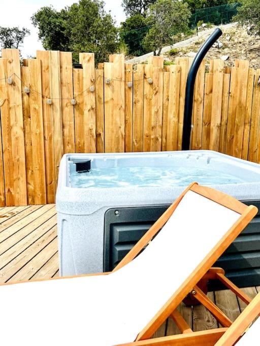 un bain à remous installé sur une terrasse à côté d'une clôture en bois dans l'établissement Mobil home vue exceptionnelle et spa - Domaine de l'Ile d'Or, à Saint-Raphaël 37 autres photos