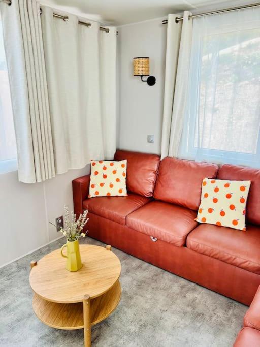 un salon avec un canapé rouge et une table dans l'établissement Mobil home vue exceptionnelle et spa - Domaine de l'Ile d'Or, à Saint-Raphaël