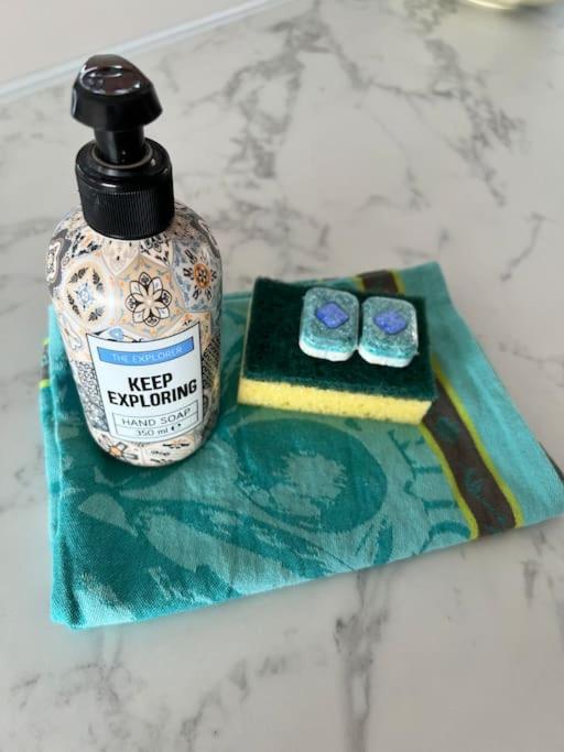 - une bouteille de savon et deux verres sur une serviette dans l'établissement Mobil home vue exceptionnelle et spa - Domaine de l'Ile d'Or, à Saint-Raphaël