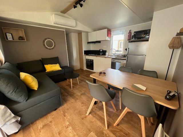 un salon avec un canapé et une table avec des chaises dans l'établissement La Cabane, à Claouey