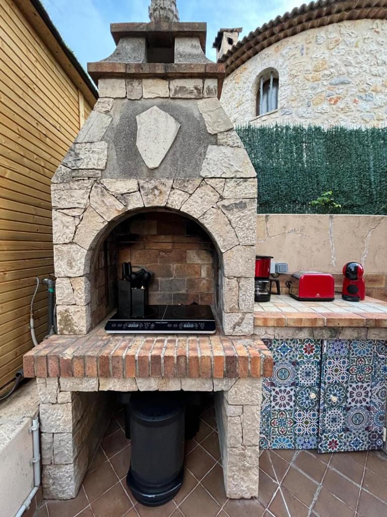 un four à briques extérieur avec un gril sur une terrasse dans l'établissement Glamping Dôme, à Cagnes-sur-Mer
