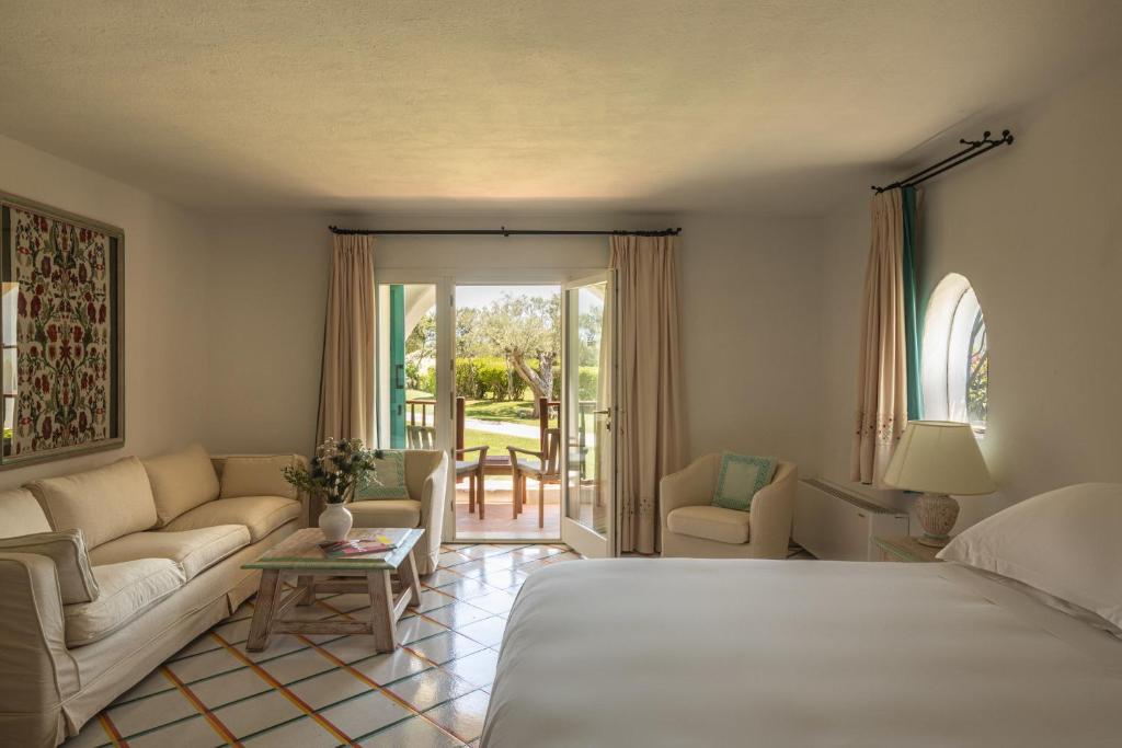 une chambre avec un lit et un salon avec un canapé dans l'établissement Romazzino, A Belmond Hotel, Costa Smeralda, à Porto Cervo 141 autres photos