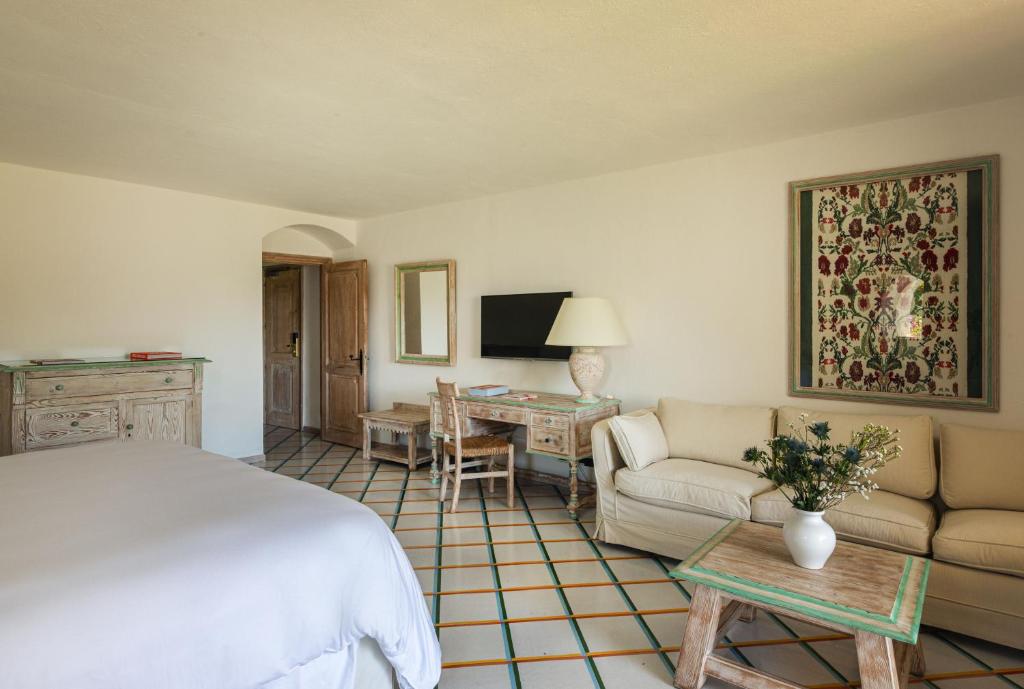 une chambre avec un lit, un canapé et une table dans l'établissement Romazzino, A Belmond Hotel, Costa Smeralda, à Porto Cervo