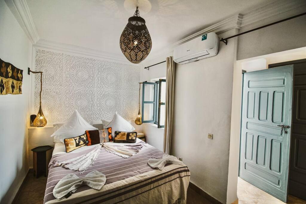 - une chambre avec un lit et une porte bleue dans l'établissement RIAD Dar Argana 100m Place Jemaa el- Fna heated Pool, à Marrakech