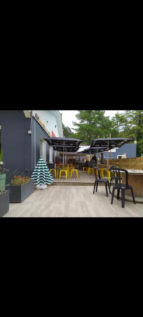 un groupe de chaises et de tables sur une terrasse dans l'établissement Mobil-home camping la Dune Blanche, à Camiers