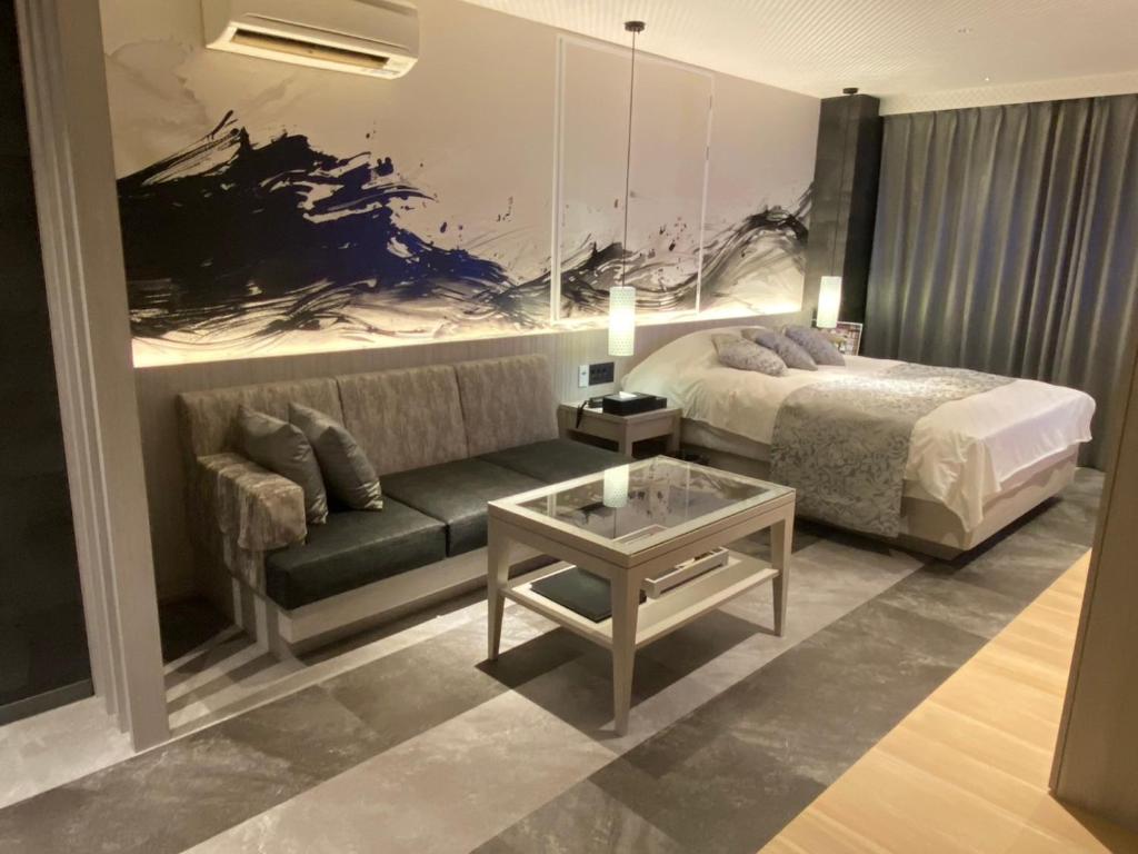 une chambre avec un lit, un canapé et une table dans l'établissement ホテル郷GO男塾ホテルグループAdult Only, à Yamatokoriyama