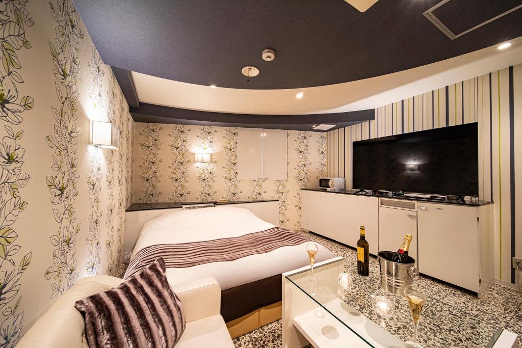 - une petite chambre avec un lit et une télévision dans l'établissement Towers Hotel - Adult Only -, à Osaka