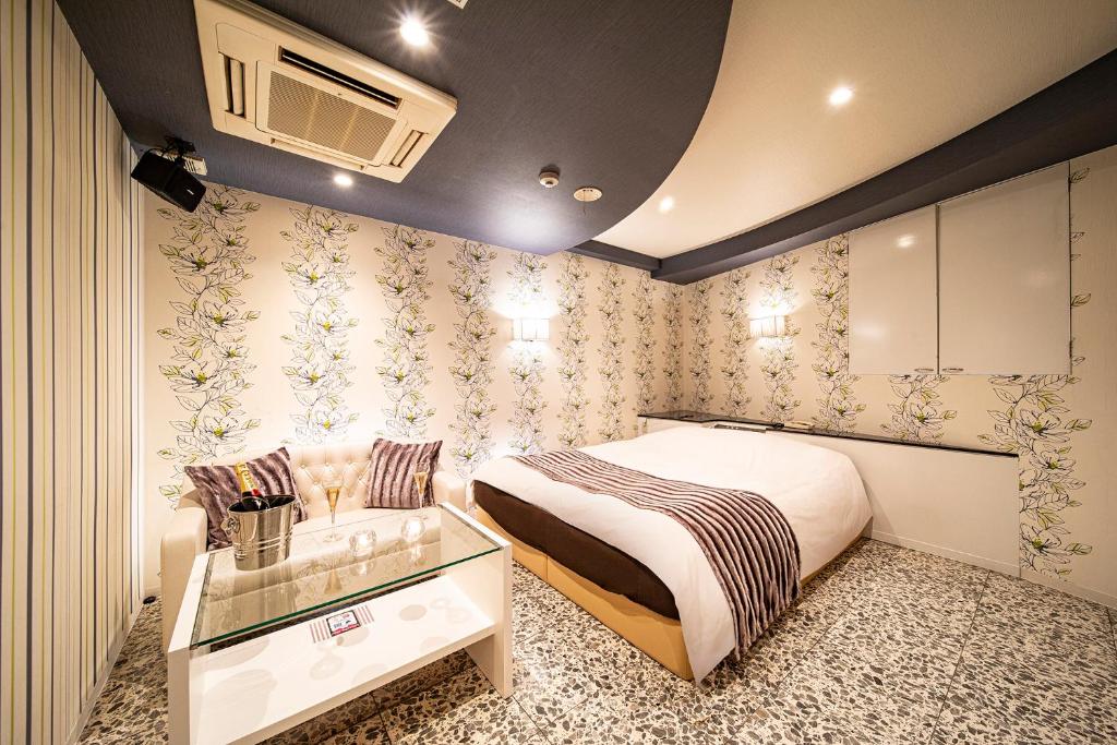 une chambre avec un lit, une table et une télévision dans l'établissement Towers Hotel - Adult Only -, à Osaka