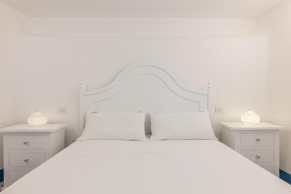 - une chambre blanche avec un lit blanc et 2 tables de chevet dans l'établissement Villa Don Carmine, à Capilungo