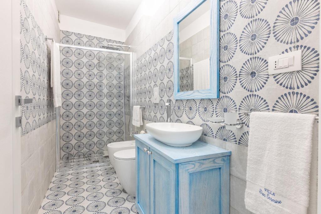une salle de bain avec un lavabo bleu et des toilettes dans l'établissement Villa Don Carmine, à Capilungo