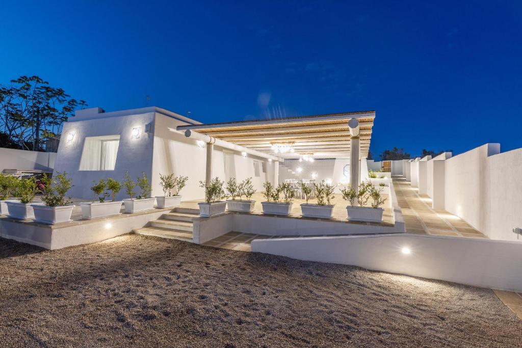 une maison blanche avec des plantes en pot devant elle dans l'établissement Villa Don Carmine, à Capilungo